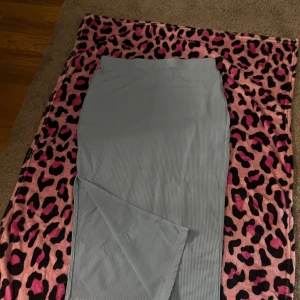 Ljusblå kjol  - Blå kjol med slit på ena sidan går precis över knäna 