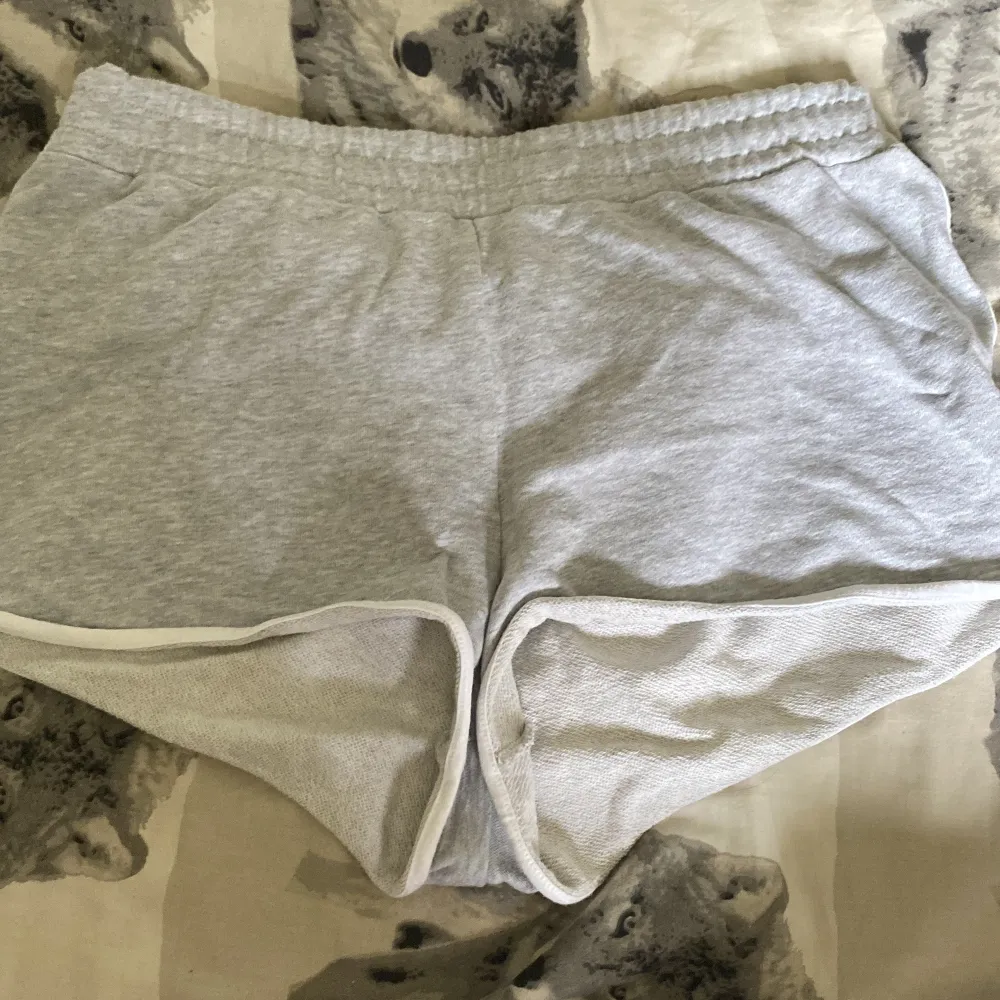 Säljer ett par grå shorts från FB Sister i storlek L. De är superbekväma med elastisk midja och vita kanter. Perfekta för en avslappnad dag hemma eller en snabb tur till affären. Materialet känns mjukt och skönt mot huden.. Shorts.