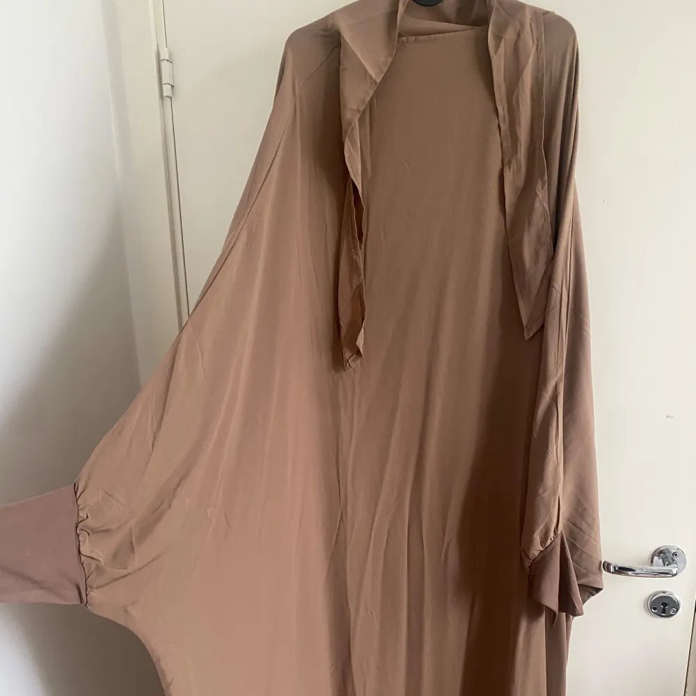 Brun Jilbab, jag är 172 och den är perfekt längd för mig men passar även för lite längre personer då den täcker mina fötter och nuddar golvet lite. Aldrig använt.. Klänningar.