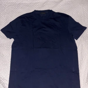 PRADA T-SHIRT - Säljer nu min mörkblåa Prada T-shirt. Ny pris ligger på 7500kr och mitt pris blir 2699kr pågrund av knappt några defekter! Hör av er vid frågor!