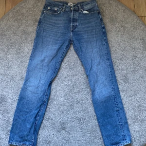 Blå jeans från 157 - Säljer ett par klassiska blå jeans från märket 157. De har en straight passform och är i nyskick. Perfekta för både vardag och fest! Jeansen har en traditionell design med fem fickor och knappgylf.