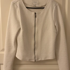 vit kofta  - Söt vit kofta med mönster och drag kedja från vila 