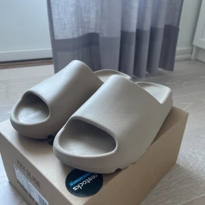 Yeezy slides - Säljer dessa Yeezy slides som är köpta på restocks hemsida. Finns en liten defekt som man kan se på bild två men syns knappt. Skulle säga att de passar storlek 42  Tveka inte på att komma med frågor🌟