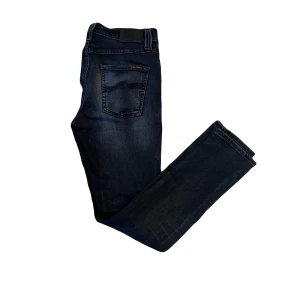 Nudie jeans - Nudie jeans med skön slitning. Storlek 29/32. Ändå defekten är att lite tråd har släppt vid fotanklarna (lätt att sy upp igen) därav priset. 