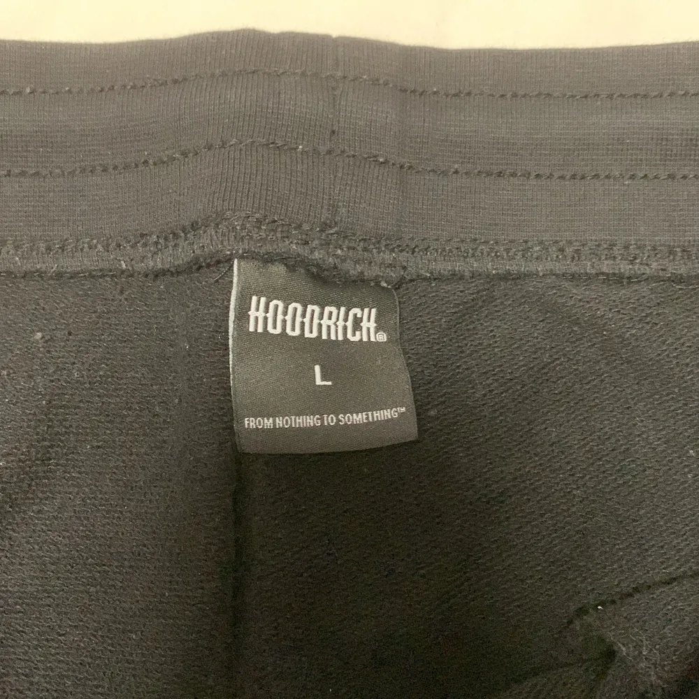 Säljer ett par snygga svarta shorts från Hoodrich. De har en cool streetwear-stil med blå detaljer och en justerbar dragsko i midjan. Perfekta för en avslappnad look i sommar. Shortsen är i bra skick och den har inga hål. . Shorts.