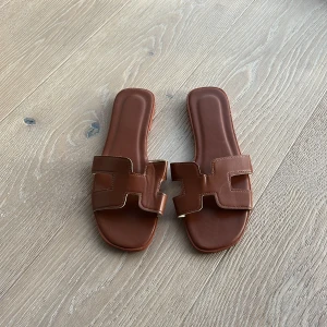 Bruna sandaler - Jättefina bruna sandaler som liknar dem från Hermés, helt nya och oanvända, säljer pga fel storlek. De är i storlek 39 men är små i storleken, skulle säga att de passar 36-38