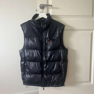 Ralph Lauren väst - Ralph Laurent väst. Västen är använd men är i bra skick . Storlek M. Nypris är ca 5000kr. Den har en liten defekt (hål som är igen sytt) men inget man tänker på. Syns lite på sista bilden till höger om västan. Hör av dig vid frågor eller mer bilder!