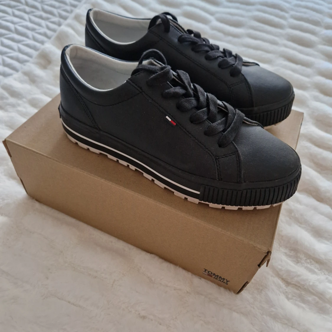 Ett par mörk blåa skor Tommy Jeans