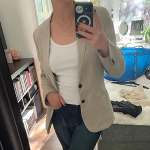 Beige kavaj - Snygg beige kavaj köpt second hand! Små fläckar på vänster sida, se bild 3, inte gjort mer än att tvätta kavajen i maskin en gång så kanske går att få bort med mer effort..  Ingen lapp med storlek eller märke hittas, sitter oversized på en xs-m. 