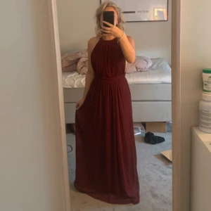 Vinröd balklänning  - Säljer min vinröda balklänning från Nelly som jag använt 1 gång på min studentbal ❤️ den är köpt begagnad men endast använd 2 gånger. Obs den är uppsydd och passar om man är runt 160 cm (jag på bild är 155cm) men man kan också sprätta upp klänningen ❤️