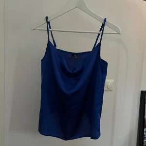 Blues topp - En underbar blues top i en mörk blå färg från VERO MODA. Man kan spänna den i axlarna så den kommer högre upp eller längre ner.  Storlek M, men passar även dom som bär S så både S och M. 