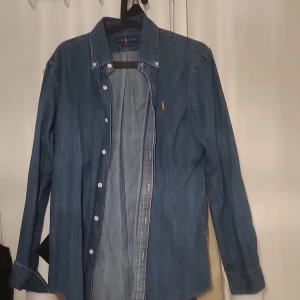 Polo Ralph Lauren Slim Fit Shirt Denim Dark Wash - Bra skick, behöver bara strykas lite. Köpt från johnells förra året, inte tagit på mig den alls. Nypris ligger runt 1300