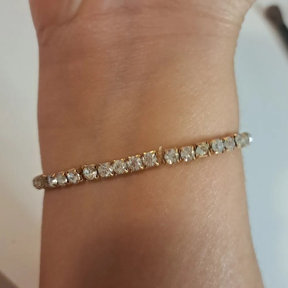 Säljer ett superglittrigt armband med klara stenar som verkligen fångar ljuset. Perfekt för att lägga till lite extra bling till din outfit. Armbandet är elegant och passar både till vardags och fest. Ett måste för alla som älskar att glittra!. Accessoarer.