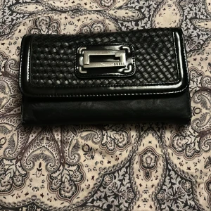 Guess plånbok/kuvertväska - I använtskick, lädret är slitet på hörnen men fin i övrigt.😊