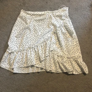 Vit prickig kjol - En söt kjol i bra skick som man stänger med dragkedja. Superfin till sommaren!