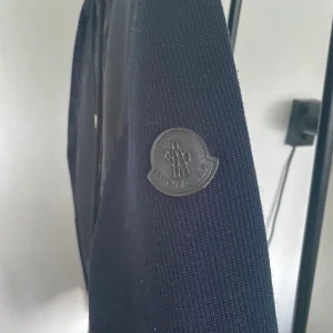 Moncler cardigan  - Hej, jag säljer en Moncler jacka som är i bra skick. Kanten på armarna är lite nötta men allt annat med jackan är i bra skick. Om det finns andra funderingar så är det bara att höra av sig. 