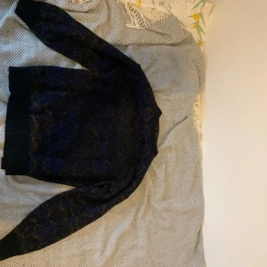 Fin stickad tröja med detaljer - (PRIS KAN DISKUTERAS!) Riktigt snygg svart stickad tröja med mörkblå detaljer som ibland skiftar åt det lila hållet. Tycker mycket om den här tröjan och den är riktig hög kvalitet, tyvärr tycker min flickvän inte lika mycket om den.