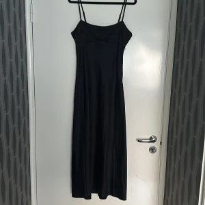 Satin klänning - En vadlång satin klänning från H&M, med dragkedja på sidan. Använd endast en gång. Storlek S