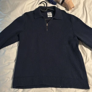 Mörkblå tröja med dragkedja från Dobber - Säljer en stilren mörkblå tröja från Dobber i storlek medium. Tröjan har en dragkedja vid halsen och ribbade kanter vid ärmslut och nederkant. Perfekt för en avslappnad och snygg look.