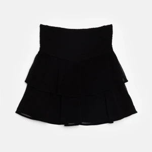 Svart volangkjol - Snygg svart kortkjol med volanger som ger en trendig look. Perfekt för att skapa en stilren outfit. Kjolen har en hög midja och är tillverkad i ett lätt och luftigt material.