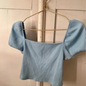Ljusblå ribbad topp - Säljer en söt ljusblå ribbad topp med  puffärmar.Använd nån enstaka gång🩵.      