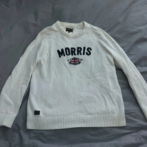 Vit tröja från Morris - Säljer en stilren vit tröja från Morris med broderad text och en brittisk flagga på bröstet. Tröjan har långa ärmar och ribbade kanter vid ärmslut och nederkant. Storlek XL men sitter mer som M/L. Bra skick! 