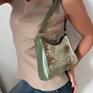 Grön handväska i vintage stil  - Snygg grön handväska med ett vackert blommigt mönster. Använd en gång.