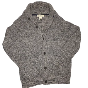 Gråmelerad kofta från L.O.G.G. - Säljer en stilren gråmelerad kofta med knappar framtill. Koftan har en bekväm passform och är perfekt för kyligare dagar. Den är långärmad och har en klassisk design som passar till det mesta.