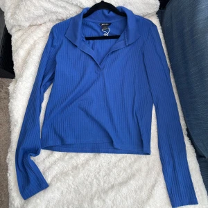 Blå tröja med vringad krage - Snygg blå ribbad tröja från Monki med långa ärmar och en stilren krage. Perfekt för en avslappnad men ändå stilfull look. Passar bra till både jeans och kjol. Så bra till konsert!💕🌸💕