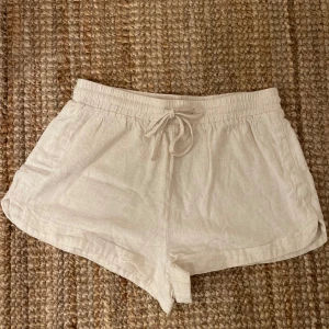Beige linne shorts - Snygga beige shorts i linne med elastisk midja och knytband. Perfekta för varma sommardagar med en avslappnad passform. De har en enkel och stilren design som gör dem lätta att matcha med olika toppar. Kan mötas upp i Stockholm eller skickas mot fraktkostnad.
