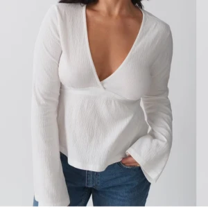 Vit omlottopp med knytband - Snygg vit omlottopp med v-ringning och långa ärmar. Aldrig använd 🌸