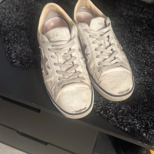 Vita sneakers från Premiata - Säljer ett par grå sneakers från Premiata med snörning och en stilren design. Skorna har en robust sula och är tillverkade i skinn. Perfekta för en avslappnad stil. Skorna är ganska slitna tyvärr och krävs nya sulor därför är priset lägre. Men priset kan lätt diskuteras😁
