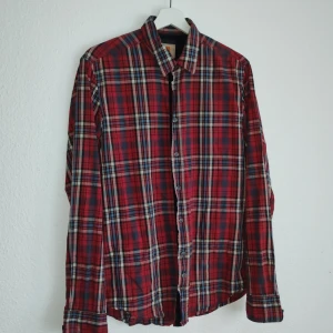 Rutig skjorta från Boss Orange - Snygg rutig skjorta från Boss Orange i rött, svart och beige. Skjortan har långa ärmar och knappar framtill. Perfekt för en stilren look.