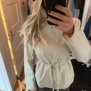 Faux-skinn jacka - Supersnygg krämvit jacka i fuskskinn. Knappast använd. Går att ha på flera sätt som ni ser på bilderna. 