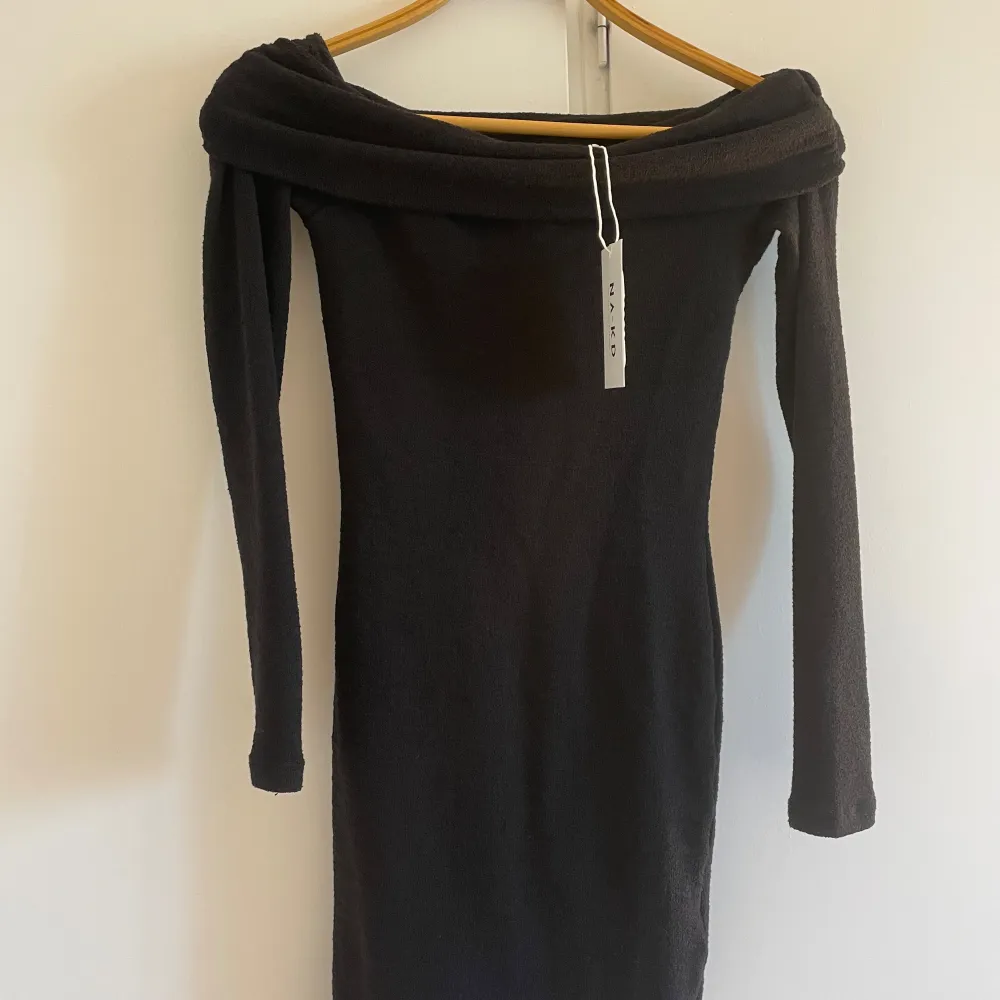Snygg svart offshoulder klänning med lång ärm och tight passform. Perfekt för en kväll ute eller en speciell tillställning. Klänningen har en elegant design som framhäver axlarna. Är en XXS men passar även xs,s. Mekot.