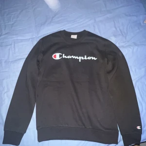 Svart sweatshirt från Champion - Säljer en svart sweatshirt från Champion med deras ikoniska logga på bröstet och ärmen. Hör av er vid minsta fråga eller fundering. Pris kan diskuteras.