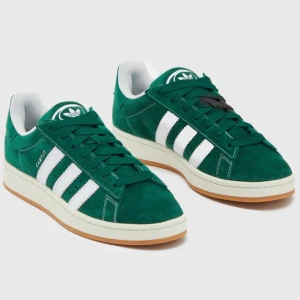 Gröna Adidas Campus sneakers st 38 - Snygga gröna Adidas Campus sneakers i mocka med vita detaljer endast andvända ett få gånger har fortfarande kartongen hemma. Skorna har en gummisula och snörning framtill. Köpta för 1 400kr 