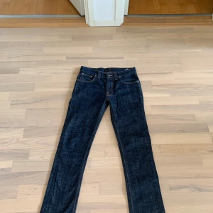 Mörkblå jeans från Nudie Jeans - tigt snygga mörkblåa nudie jeans. Inga slitningar eller skador och använde ett fåtal gånger. Normala i storleken. Storlek 30/32. Kom privat för fler bilder