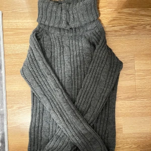 Grå stickad polotröja från ONLY - Säljer en supermysig grå stickad polotröja från ONLY. Perfekt för kalla dagar med sin tjocka krage och snygga kabelstickade mönster. Tröjan har långa ärmar och en knappdetalj vid kragen. Passar perfekt till både vardag och mysiga hemmakvällar. Storlek M men passar även S🧶✨pris kan diskuteras 