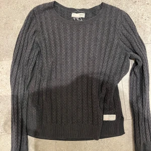 Mörkgrå stickad Odd Molly tröja  - Säljer en snygg mörkgrå stickad tröja från Odd Molly. Den har ett klassiskt flätmönster och är i  bra skick. Perfekt för höst och vinter, med långa ärmar och ribbade kanter. 
