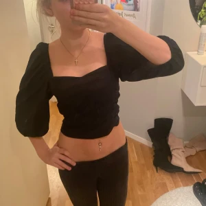 Svart croppad topp med puffärmar - Hejj! Säljer en supersnygg svart croppad topp med puffiga ärmar. Toppen har en åtsittande passform och är perfekt för festliga tillfällen. Den är i mycket bra skick och har inga defekter. Köpte tröjan på Gina Tricot förrra året inför nyår men den kom aldrig till användning. Verkligen en perfekt topp till nyår!! Hör mer än gärna av dig om du skulle ha några frågor!
