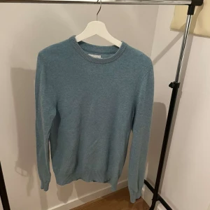 Blå stickad tröja - Säljer en  blå  stickad tröja, Tröjan har långa ärmar och en klassisk rund halsringning. Passar både till vardags och lite finare tillfällen. Materialet är lambswool och är i storlek S 
