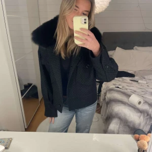 Svart jacka med pälsdetalj från Meotine - Säljer en snygg svart jacka från Meotine i storlek S/M. Den har en elegant pälsdetalj vid kragen och knappar framtill. Perfekt för höst och vinter, med en stilren look som passar både till vardags och fest. 🖤(säljer åt en kompis, därav inte jag på bilderna)
