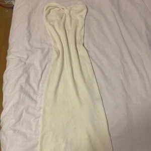 Stickad klänning  - Säljer en superfin beige stickad klänning i ett mjukt material. Den är axelbandslös och är otroligt stretchig. Den är i storlek S men skulle passa hela vägen till L. Perfekt för fester på vintern. Klänningen har jag aldrig använt utan att testa på. Vill ej ha den då mitt självförtroende för min kropp inte är så jättebra just nu. 