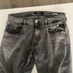 Grå Replay Anbass jeans - Säljer ett par grå Replay Anbass jeans i storlek 32. De har en snygg tvättad look och är i mycket bra skick. Perfekta för både vardag och fest! De har en klassisk femficksdesign och en bekväm passform. Pricet är ej hugget i sten 🪨 skriv om frågor eller funderingar😁😁