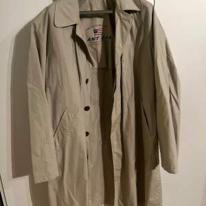 Säljer en klassisk beige trenchcoat från Gant i mycket bra skick. Storlek L amerikanskt mått så XL i svensk storlek. Den har en stilren design med knappar framtill och en bekväm passform. Perfekt för höst och vår! 🧥