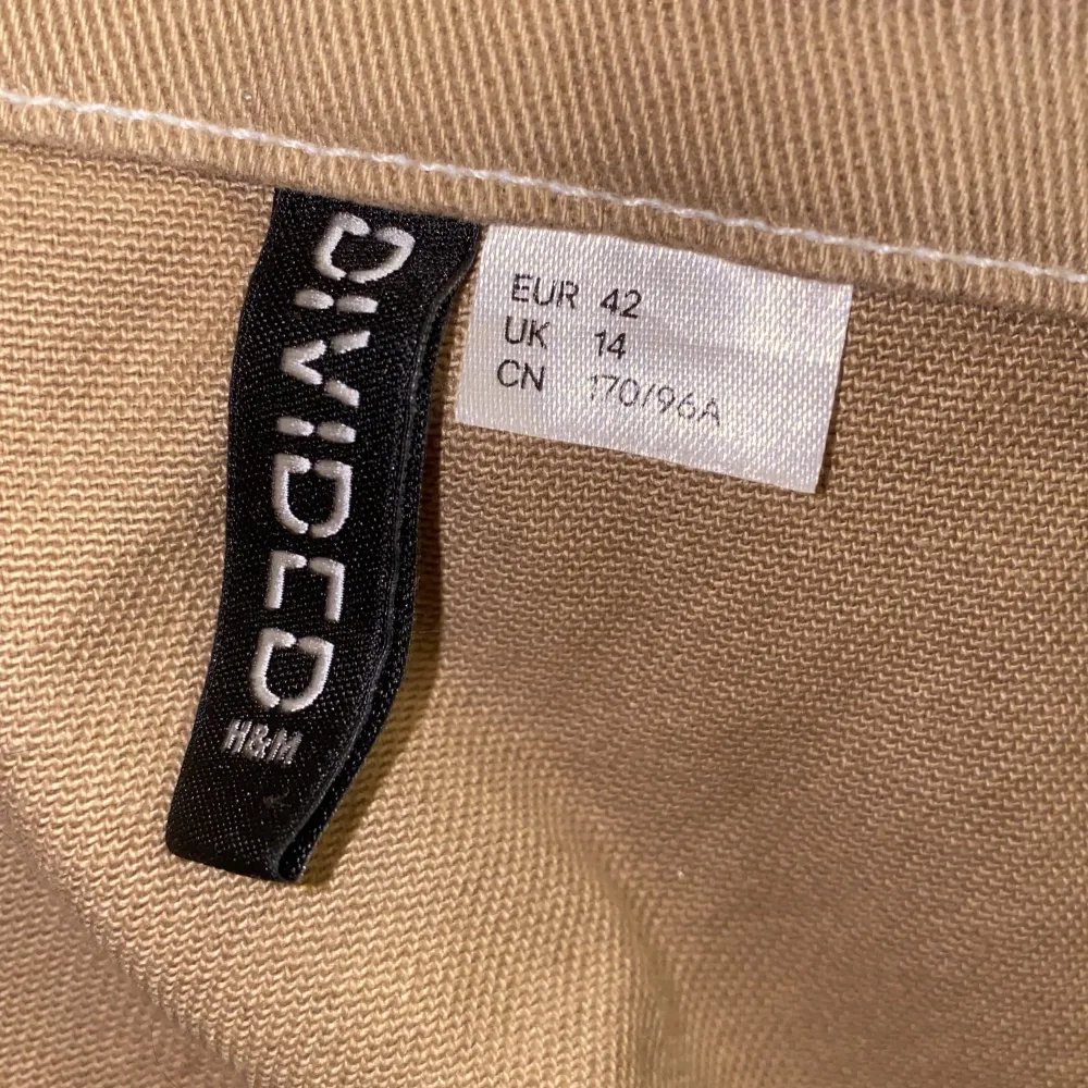 Säljer en snygg beige klänning från H&M Divided i storlek L. Klänningen har en dragkedja framtill och breda justerbara axelband. Perfekt för vår och sommar! 👜. Klänningar.