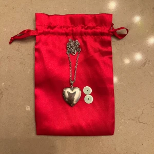 Silverfärgat hjärtformat halsband - Säljer ett superfint silverfärgat medaljong halsband. Medaljongen kan öppnas och har plats för två små drogtester som gör det möjligt att snabbt kolla om din dryck är spikad. Perfekt som en present eller för dig själv så att du och dina nära och kära kan känna er sökte när ni är ute. Medaljongen kommer i en snygg röd påse. 💖