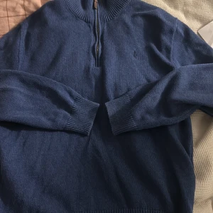 Blå tröja från Ralph Lauren - Säljer en snygg blå tröja från Ralph Lauren i storlek M. Tröjan har en dragkedja vid halsen och är i mycket bra skick. Perfekt för höst och vinter med sin mysiga och stilrena design. Passar både till vardags och lite finare tillfällen.