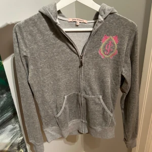 Grå hoodie från Juicy Couture - Säljer en snygg grå hoodie från Juicy Couture i storlek XL men är barn storlek så den är som en XS/S. Vissa glitter stenar är borta tyvärr!!